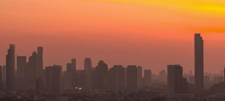 Air pollution. Smog and fine dust of pm2.5 covered city in the morning with orange sunrise sky. Cityscape with polluted air. Dirty environment. Urban toxic dust. Unhealthy air. Urban unhealthy living.