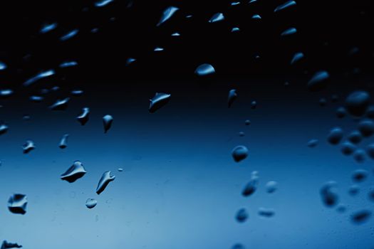 Liquid water drops on glass surface, abstract backdrop and science background concept