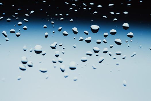 Liquid water drops on glass surface, abstract backdrop and science background concept