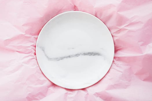 Marble plate inside pink paper packaging as flatlay background, food service flat lay and meal delivery concept