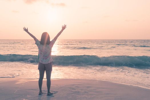 Woman rise hands up to sky travel around the world with summer beach freedom and relax life.