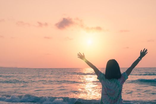 Woman rise hands up to sky travel around the world with summer beach freedom and relax life.