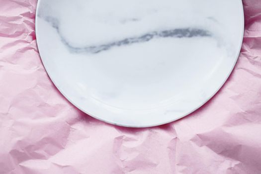Marble plate inside pink paper packaging as flatlay background, food service flat lay and meal delivery concept