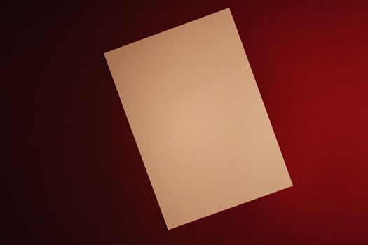 Beige A4 paper on dark red background as office stationery flatlay, luxury branding flat lay and brand identity design for mockups