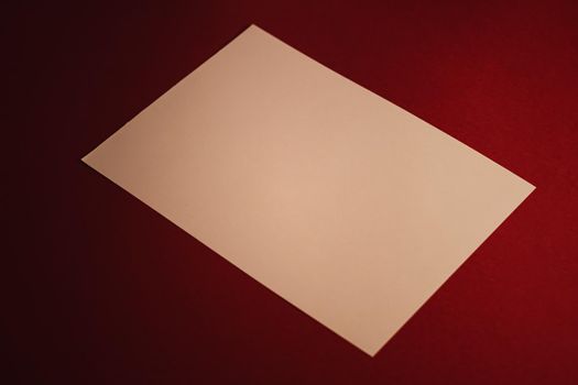 Beige A4 paper on dark red background as office stationery flatlay, luxury branding flat lay and brand identity design for mockups