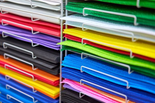 Sheets colored cardboard for designer creative works. Stacks multicolored drawing paper in the store. Colorful art papers on shelf for sale stationery store