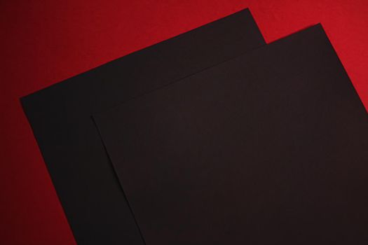 Black A4 papers on red background as office stationery flatlay, luxury branding flat lay and brand identity design for mockups