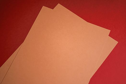 Beige A4 papers on red background as office stationery flatlay, luxury branding flat lay and brand identity design for mockups