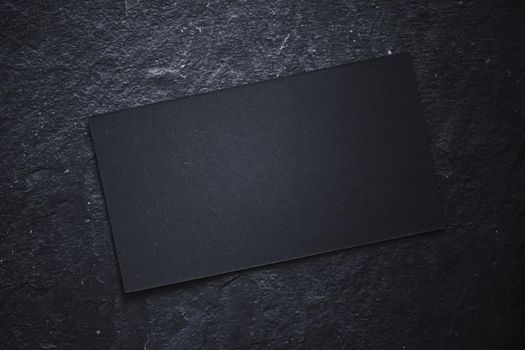 Black business card on dark stone flatlay background and sunlight shadows, luxury branding flat lay and brand identity design for mockups