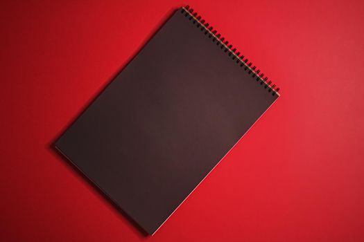 Black notebook on red background as office stationery flatlay, luxury branding flat lay and brand identity design for mockups