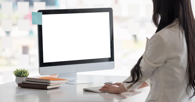 Side view of businesswoman hands typing text on a wireless keyboard. Business woman working at the office.