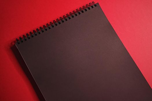 Black notebook on red background as office stationery flatlay, luxury branding flat lay and brand identity design for mockups