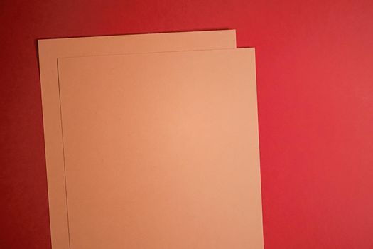 Beige A4 papers on red background as office stationery flatlay, luxury branding flat lay and brand identity design for mockups