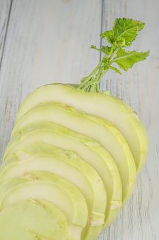 Fresh healthy kohlrabi sliced on wooden background.