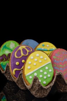 Easter decorated baked eggs, cookies on a black background.