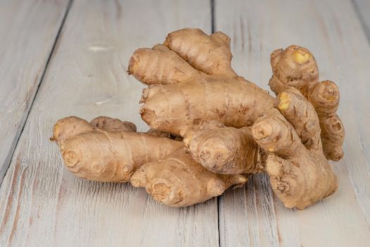 Fresh, light, healthy ginger on white wooden background.