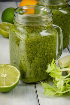 Healthy green smoothie with spinach, mango, orange,lime, apple,citrone in glass jars.