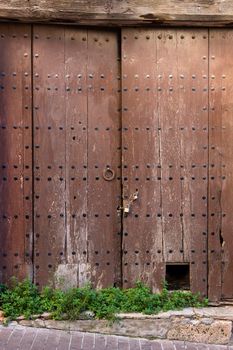 Old wooden door with stone arch, in Girona, Catalonia, Spain