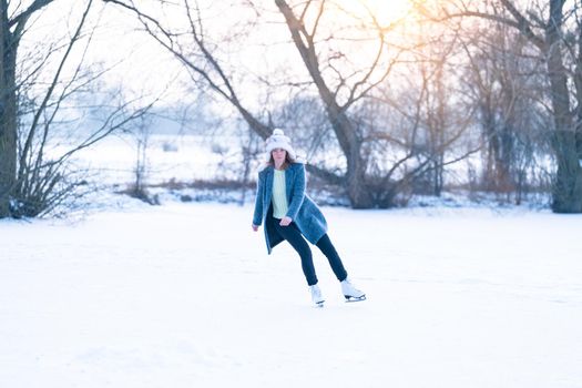 ice skating on the ice of a frozen lake young attractive woman.