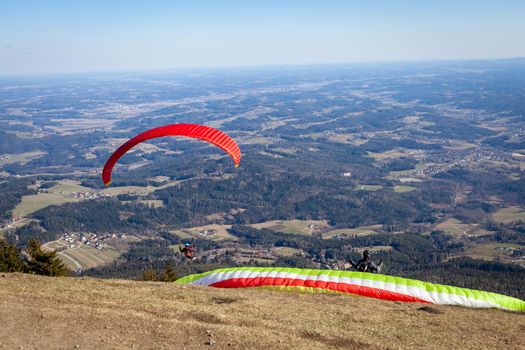 sports paragliding on a parachute over the countryside.