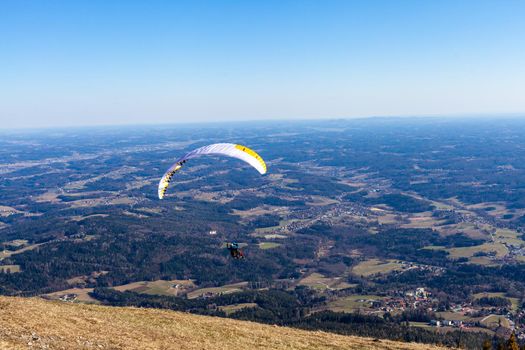 sports paragliding on a parachute over the countryside.