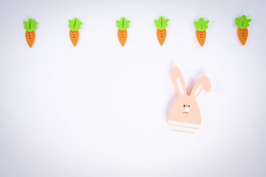 Easter pattern made with carrots and a cute Easter bunny on white background. Creative minimal holiday flat lay concept. Spring holidays concept. Top view. Copy space.