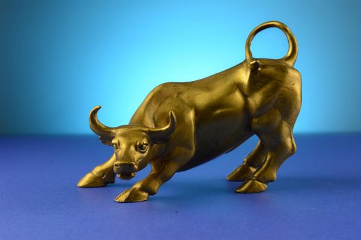 A brass bull figure over a blue gradient background to represent the power behind its natural self.