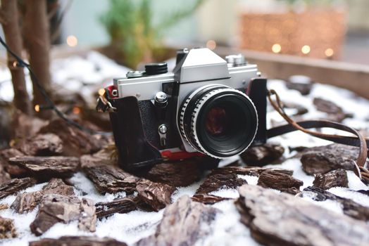 A single, old, retro photo camera it stay on the snowy ground.