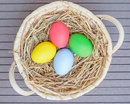 Close up Colorful easter eggs in the basket on wood background with space