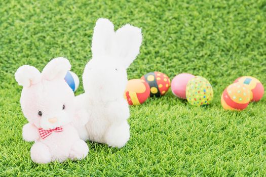 Easter bunny toy and Easter eggs on green grass