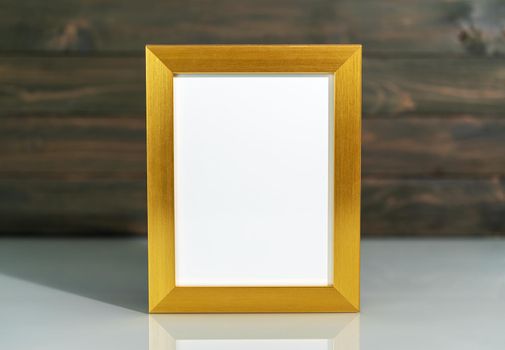 Picture golden frame mock up and Artificial flower vase bouquet over table with wood wall background