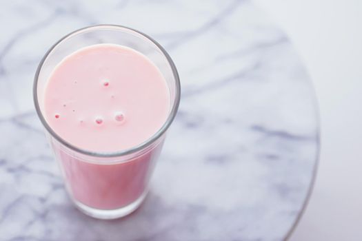 Strawberry milk on marble background as sweet drink, food service and meal delivery concept