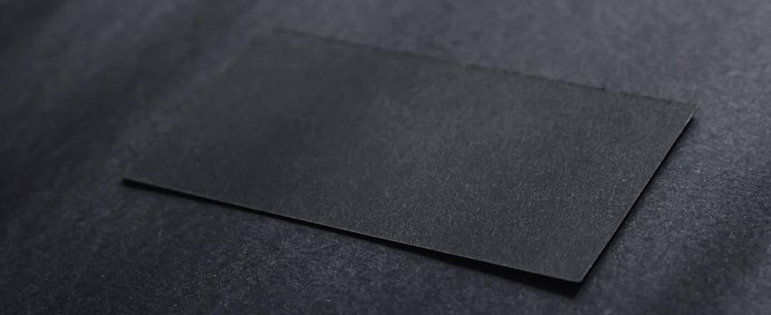 Black business card on dark flatlay background and sunlight shadows, luxury branding flat lay and brand identity design for mockups