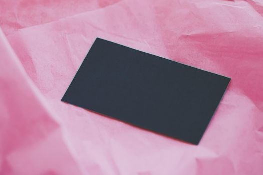 Black business card flatlay on pink tissue paper background, luxury branding flat lay and brand identity design for mockups