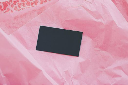 Black business card flatlay on pink tissue paper background, luxury branding flat lay and brand identity design for mockups