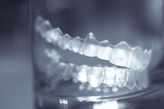 Transparent tooth aligner inside a crystal glass. No people