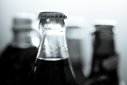 Top of a glass bottle of various soft drinks. No people