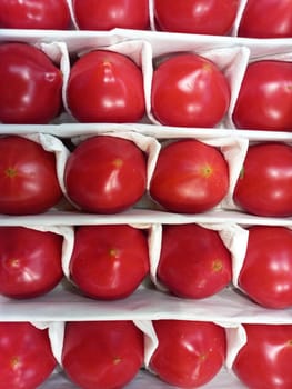 Ripe tomatoes. Red large tomatoes packed in a box. High quality photo