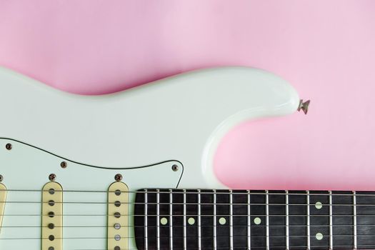 Detail of White Electric Guitar on a pink background.