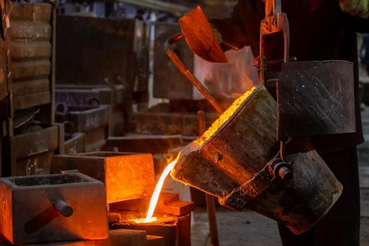 Industrial chill casting. The process of for filling out mold with molten metal from ladle.