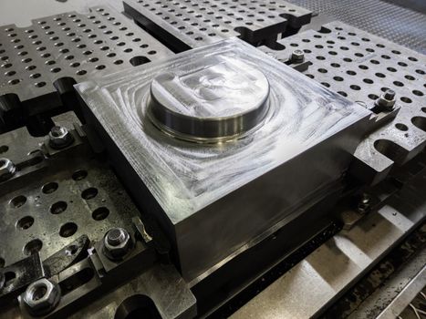 large steel workpiece after cnc surface milling on table of milling machine, industrial cnc technology backdrop.
