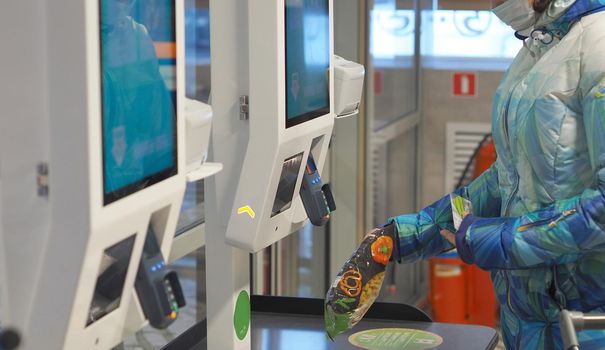 The latest Technologies. Self-service checkout in the supermarket. A woman buys groceries in a supermarket and pays for goods at the self-service checkout with a bank card.