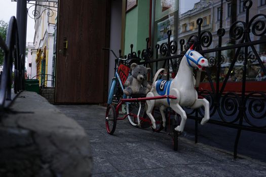A cozy courtyard with children's old attractions. Unicorn bike.Toys from the USSR.