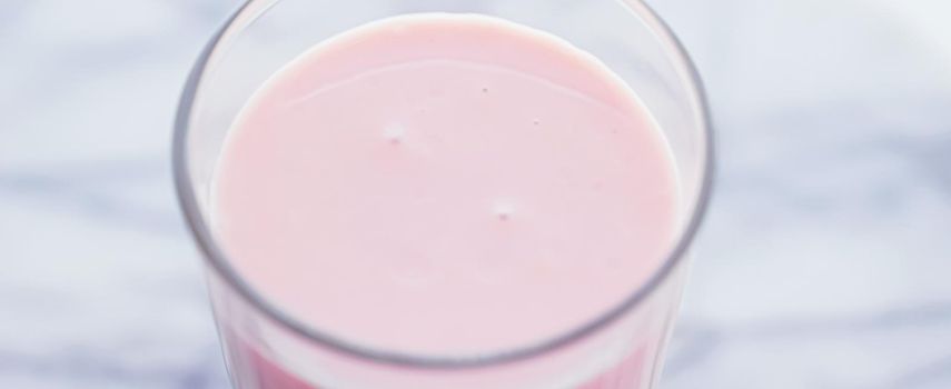Strawberry milk on marble background as sweet drink, food service and meal delivery concept
