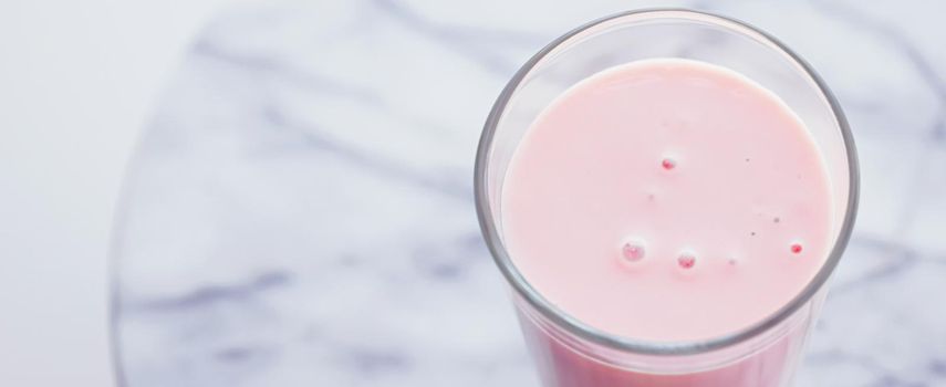 Strawberry milk on marble background as sweet drink, food service and meal delivery concept