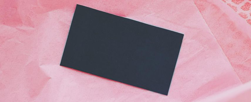 Black business card flatlay on pink tissue paper background, luxury branding flat lay and brand identity design for mockups