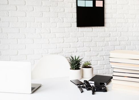 Distance learning. E-learning. light and airy workspace, teacher table with laptop, books and stationery, focus on foreground