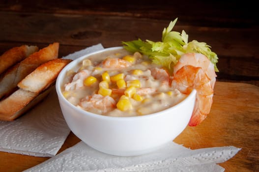 Bowl of homemade corn chowder soup with potatoes, carrots and shrimp.English shrimp chowder soup