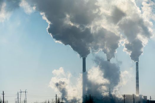 Smoking factory chimneys.Environmental problem of pollution of environment and air in large cities.Climate change,ecology and global warming.The sky is smoky with toxic substances.Soot from factories