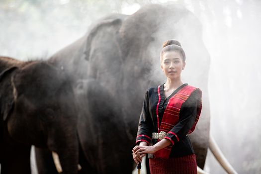 Portrait Of Young Woman Standing By Elephant In Forest